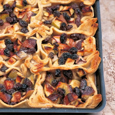A picture of cooked apples and raisins on pastry in an oblong baking tray
