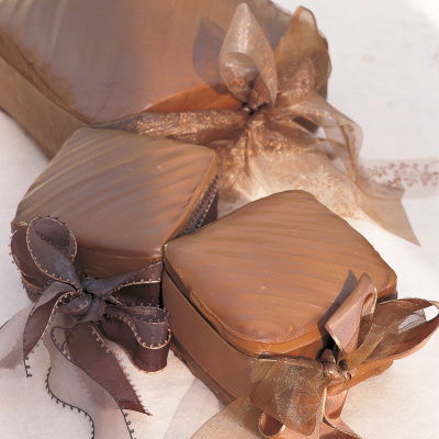 a picture of three individual cakes wrapped in gold paper and bows