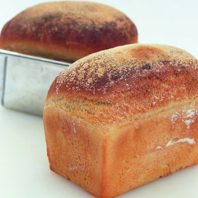picture of two white loaves, one in a tin