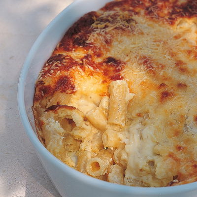 A close up picture of a white dish containing cooked macaroni cheese