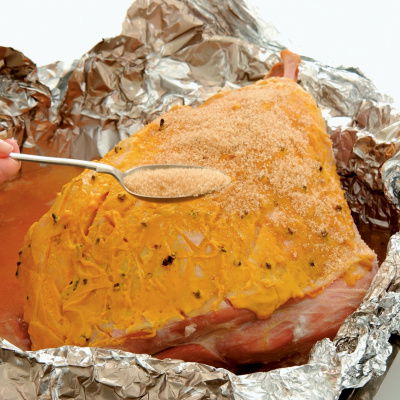 a pictur e of a whole gammon in foil being basted 