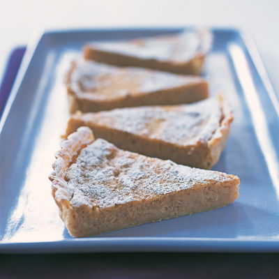 four slices of creamed apple flan on an oblong plate