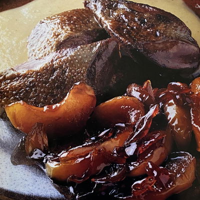 a picture of cooked wood pigeon and apples on a brown plate