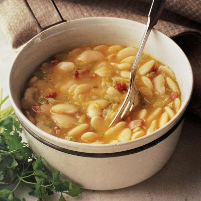A bowl of thick butterbean soup with a fork resting on the side