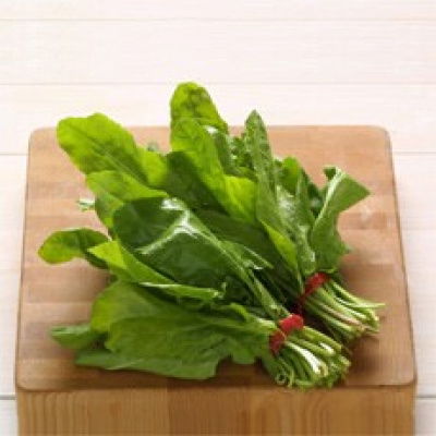 a bunch of sorrel leaves on a wooden chopping board